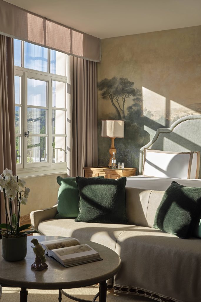 Sunlit guest room with a painted landscape wall at Collegio alla Querce