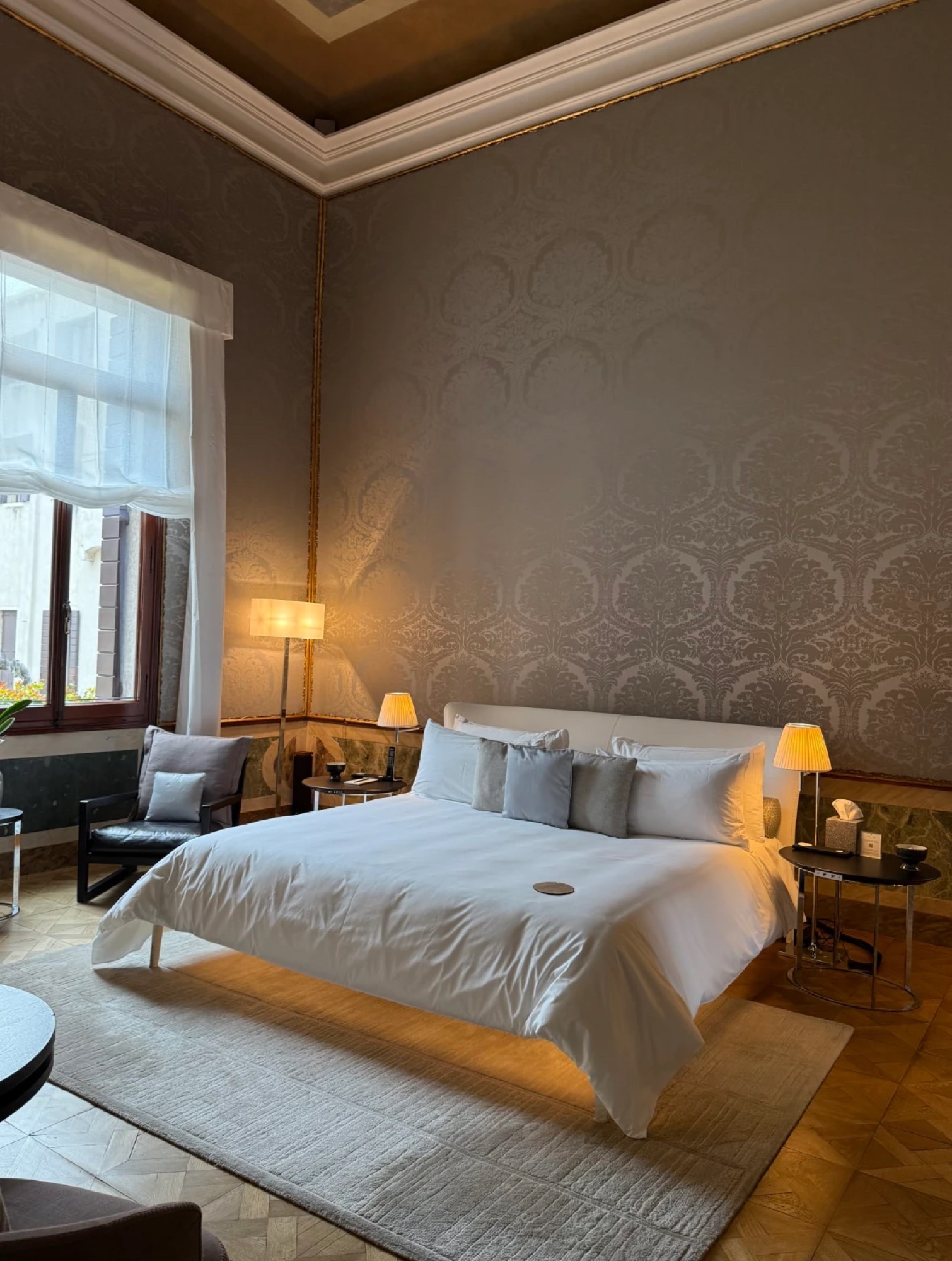 A bedroom with silk damask walls at Aman Venice
