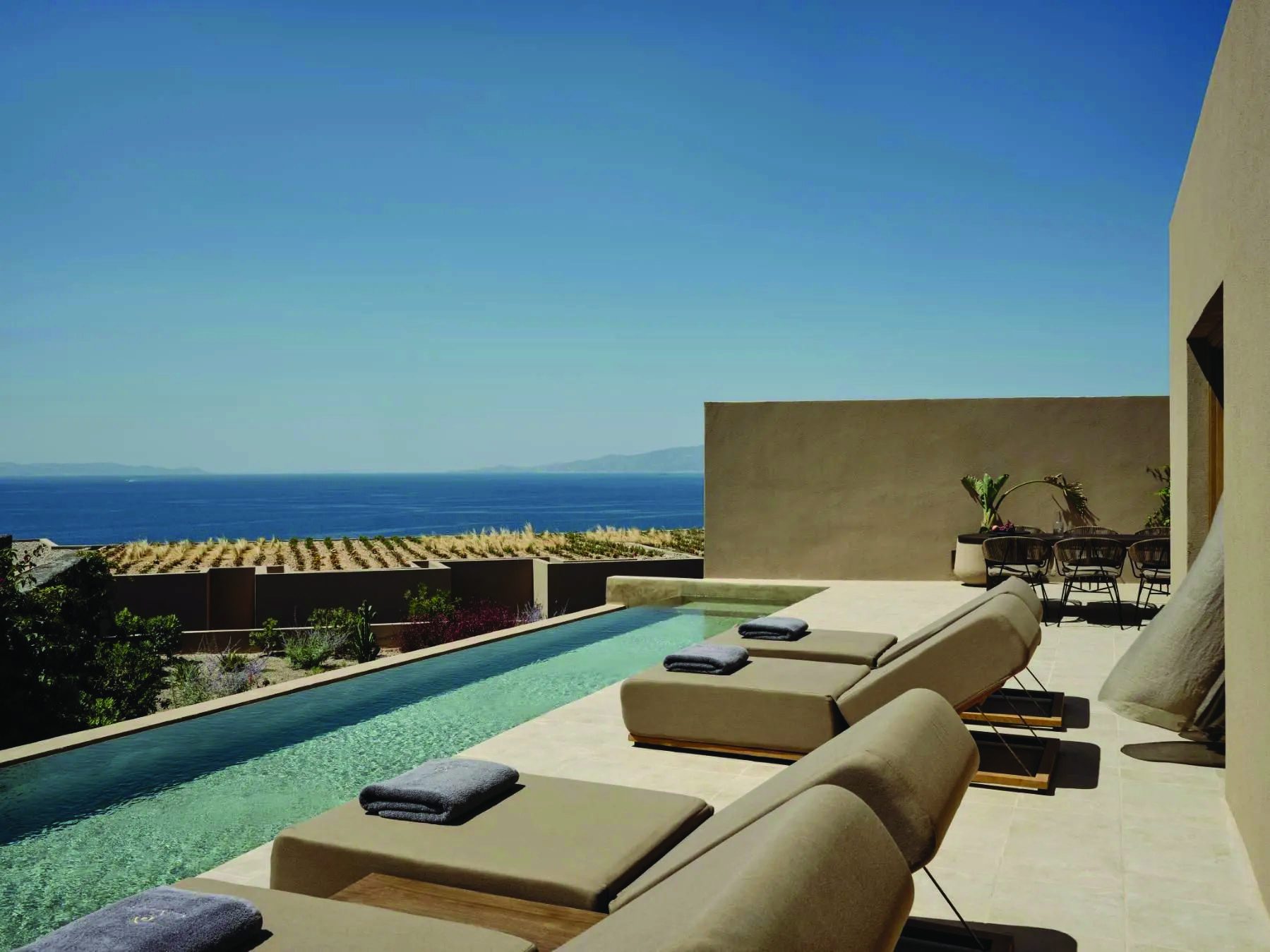 Loungers beside the infinity pool of a three-bedroom villa at Andronis Arcadia, Santorini