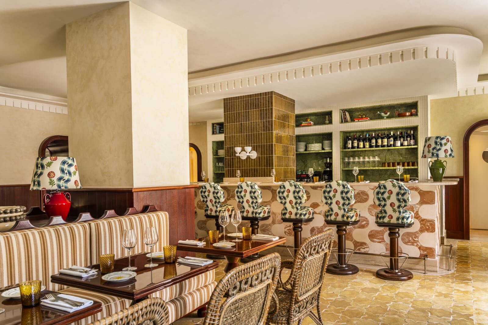 Casa Monti&rsquo;s downstairs restaurant, with striped banquettes, wicker chairs, patterned bar stools and a marble-fronted bar
