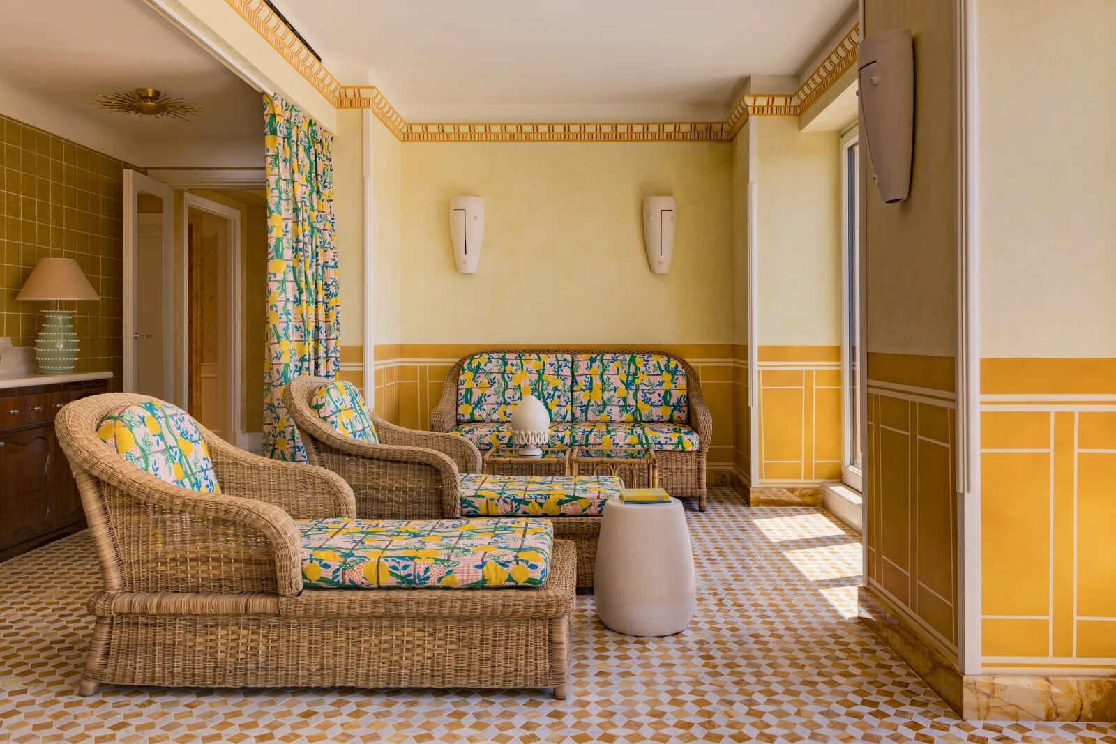 The Casa Monti spa lounge with wicker loungers in a lemon-print fabric, yellow walls and a mosaic floor