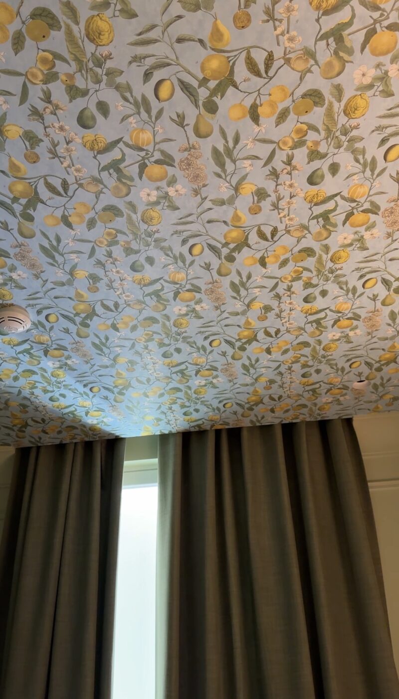 A Hotel de Russie room ceiling papered with lemons, pears and blossoms on a pale blue background