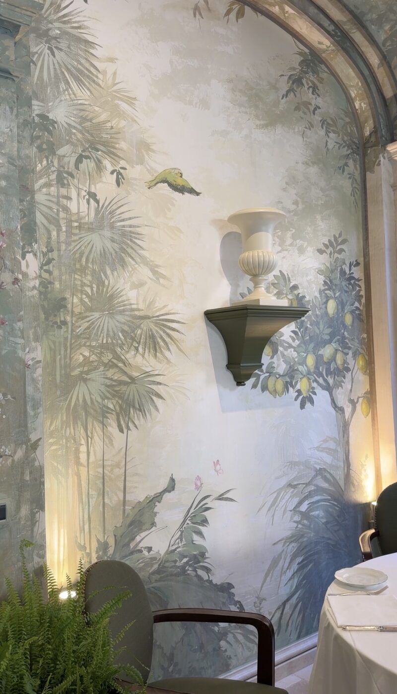 A hand-painted mural of palms, a lemon tree and a bird in a Hotel de Russie dining room