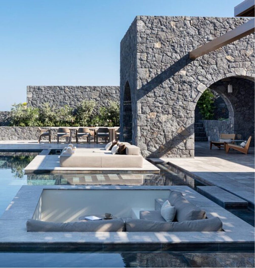 Volcanic-stone arches, a pool and a sunken lounge at a Canaves Epitome villa in Santorini