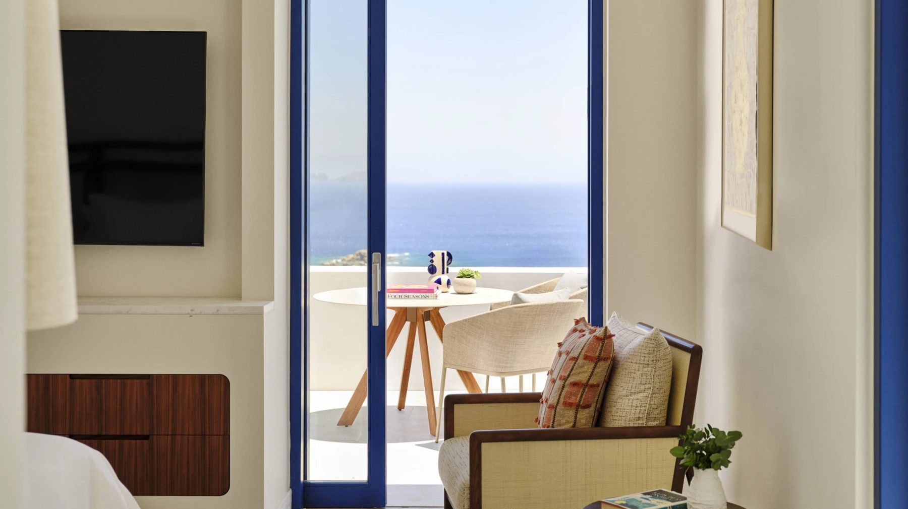A Syros Villa bedroom opening onto a sea-view balcony, Four Seasons Mykonos