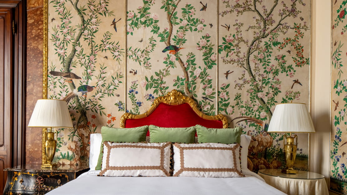 Hand-painted walls and a gilded headboard in the Volterrano Suite