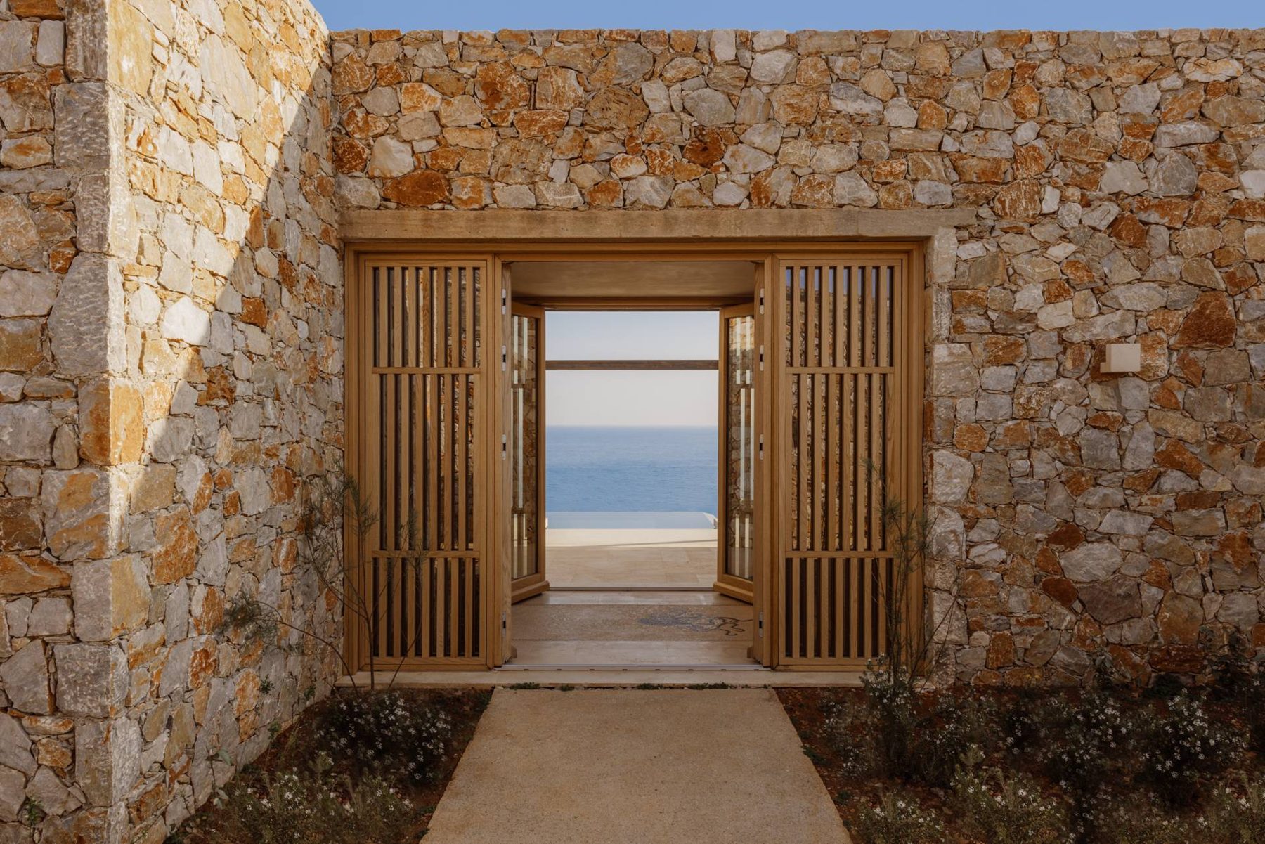 The stone entrance of the Four-Bedroom Villa at Gundari, framing the sea