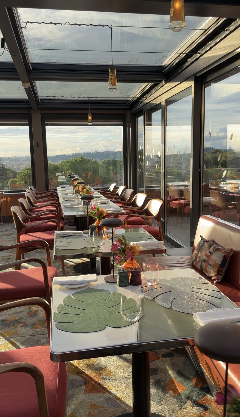 Hotel Eden&rsquo;s glass-roofed rooftop restaurant at golden hour, with views over Rome&rsquo;s rooftops and hills