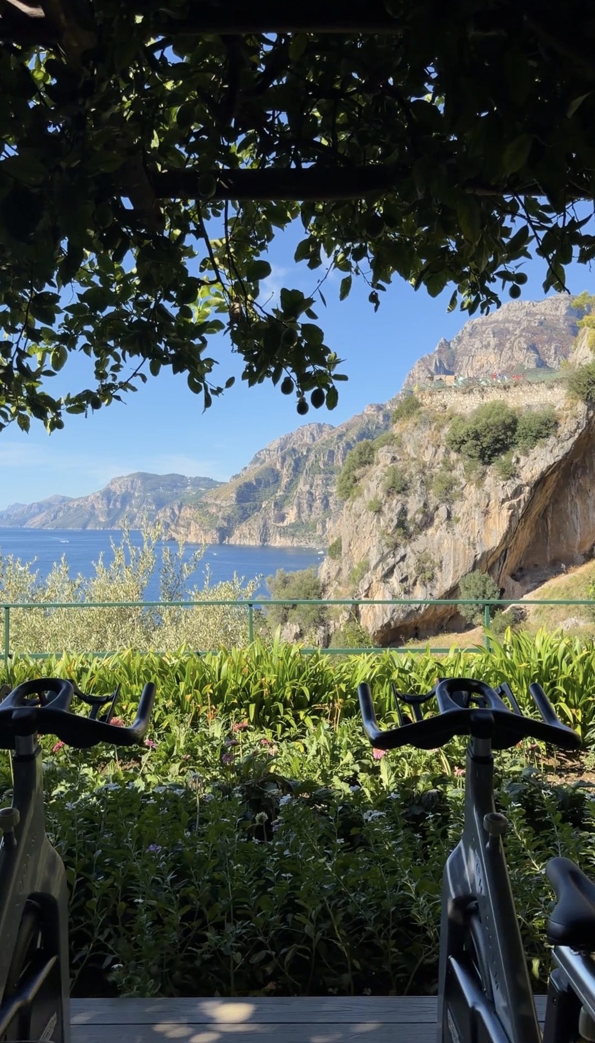 Spin bikes facing the sea and the cliffs of the Amalfi Coast under a lemon pergola at Il San Pietro