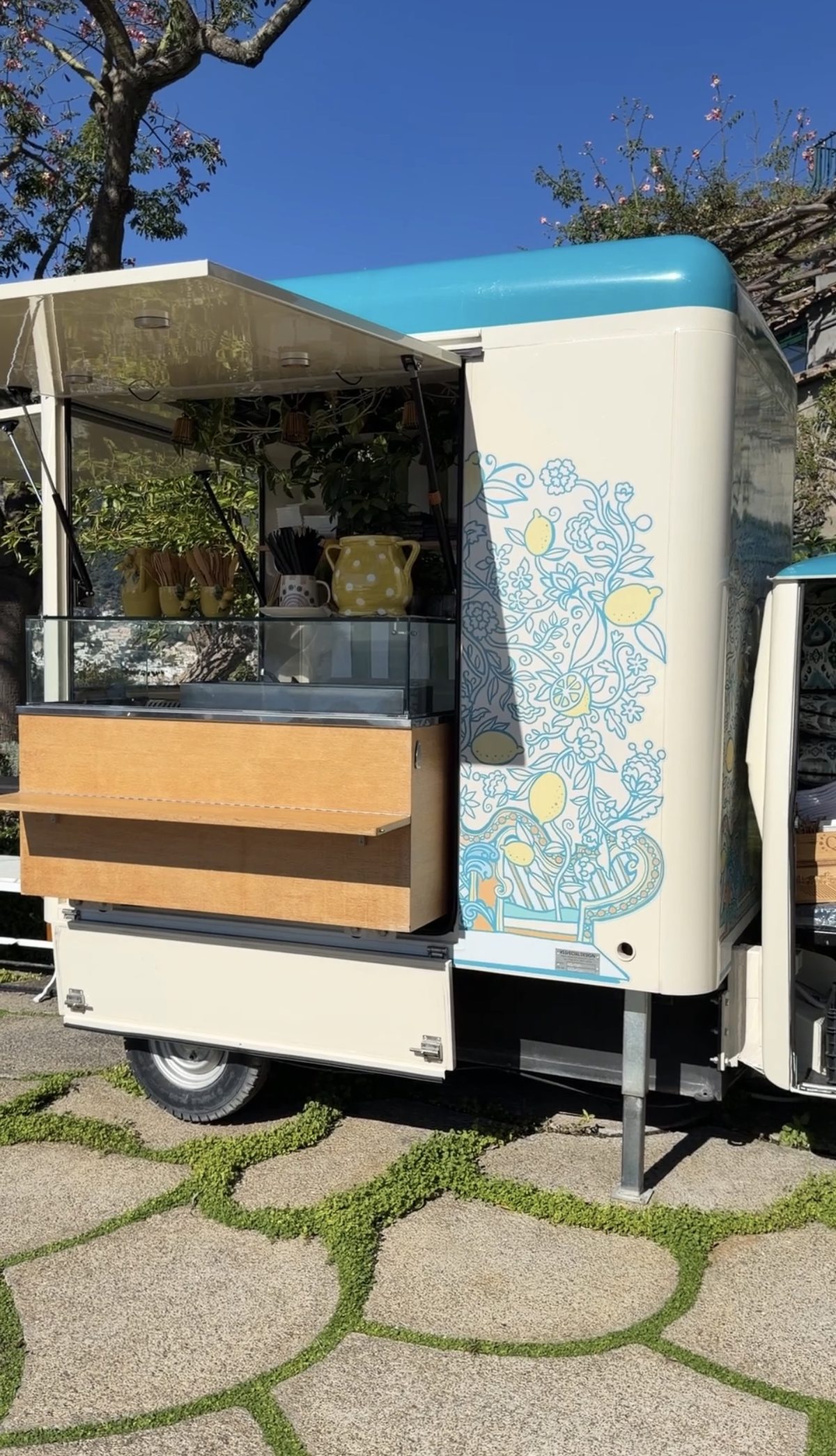 A cream and turquoise coffee and gelato cart painted with lemons on a garden terrace at Il San Pietro