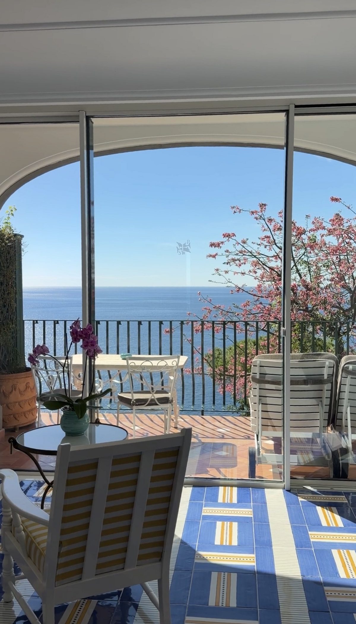 A suite at Il San Pietro with blue-and-yellow tiles opening onto a terrace over the sea