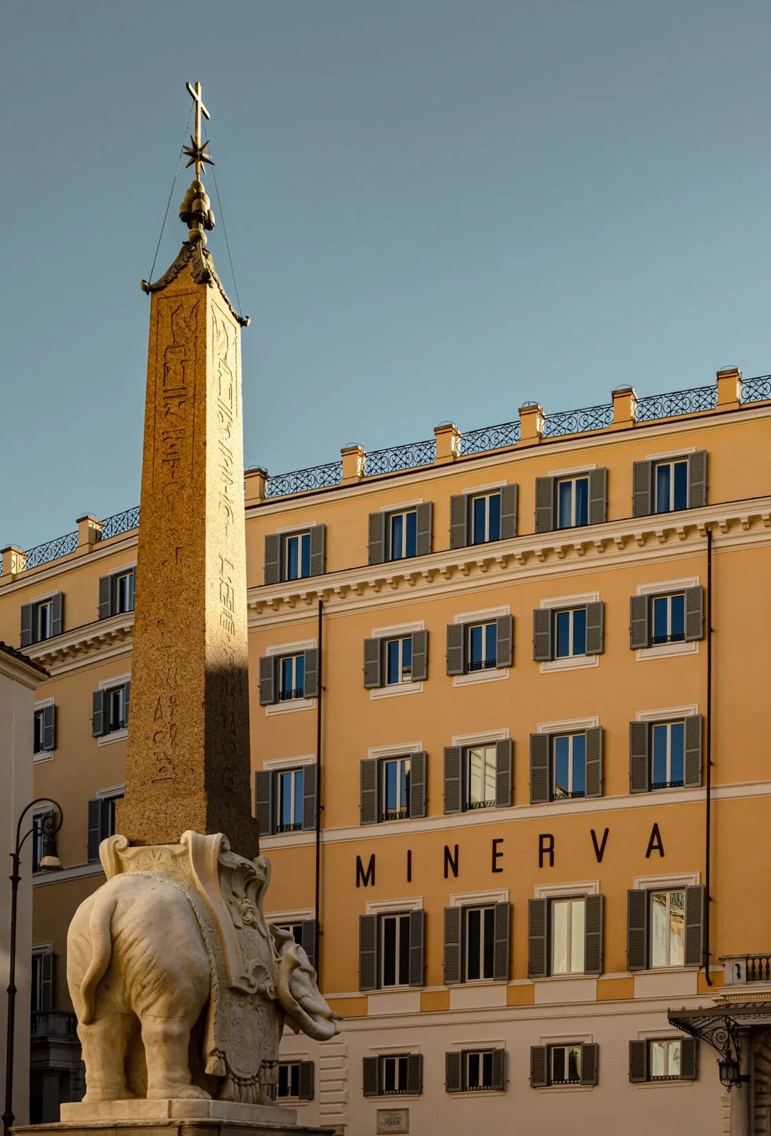 The ochre facade of Orient Express La Minerva on Piazza della Minerva, with Bernini&rsquo;s elephant obelisk in front