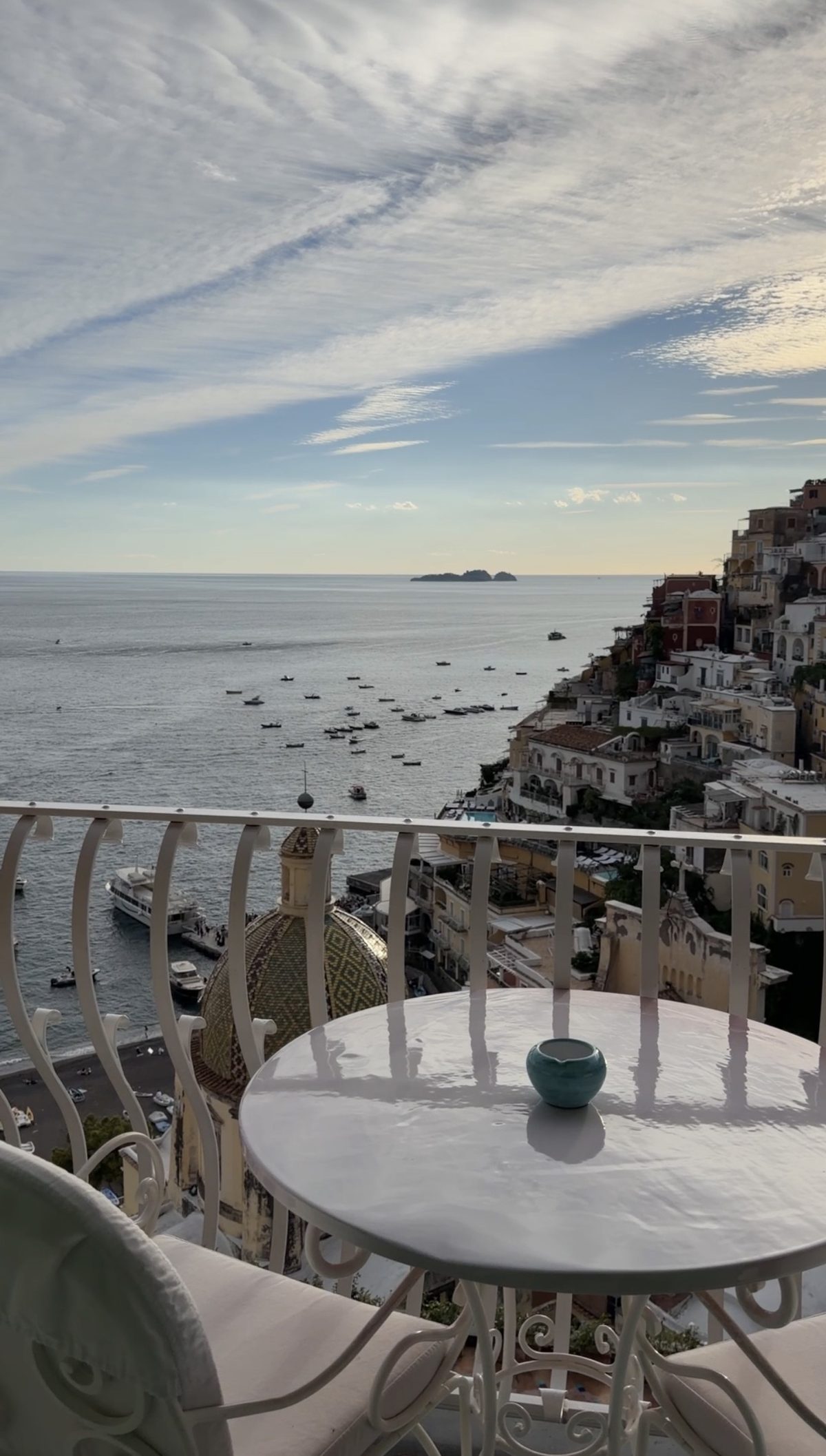 A balcony table at Le Sirenuse above the church dome and the harbor of Positano