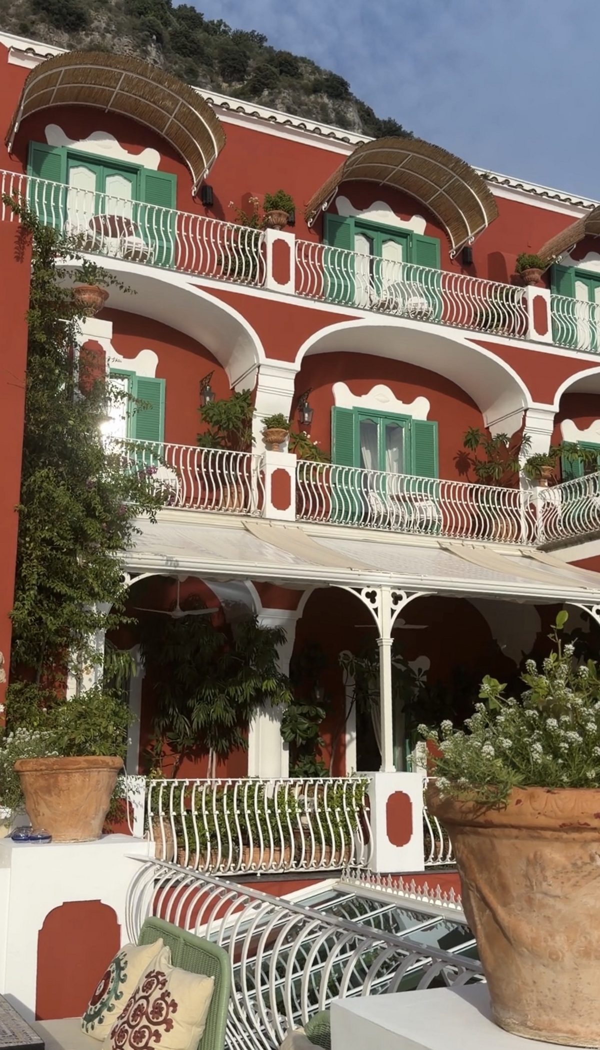 Red facade, green shutters and white wrought-iron balconies at Le Sirenuse