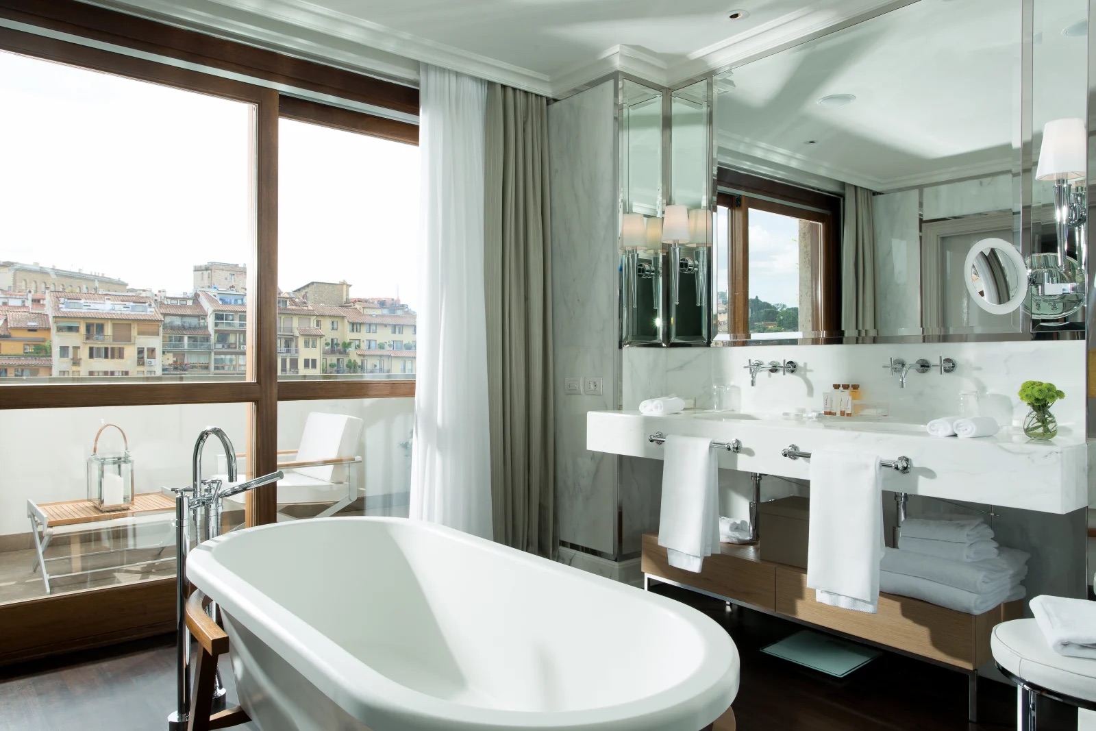 A marble bathroom with a freestanding tub opening onto a private terrace above the Arno