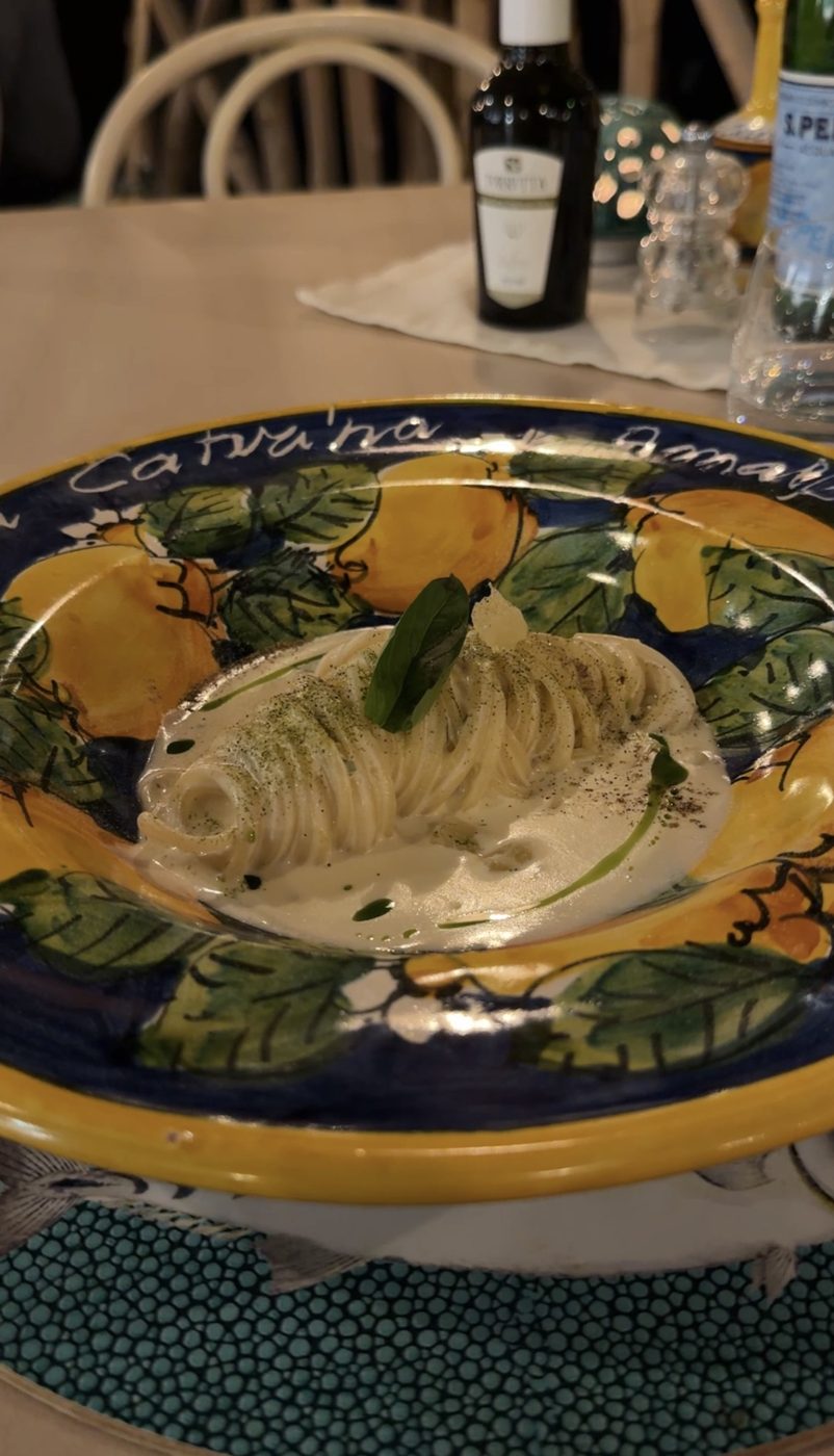 Spaghetti in a creamy sauce with basil, served in a hand-painted lemon plate bearing the hotel's name