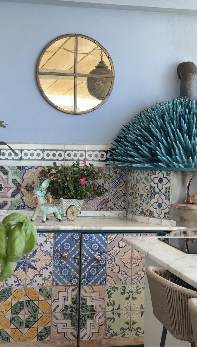 Hand-painted majolica tiles, a ceramic donkey and a turquoise sculpture in a kitchen at Villa Treville