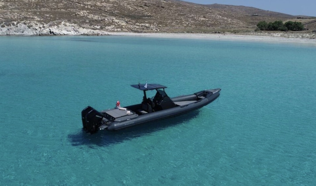 A private boat anchored in clear water off Milos