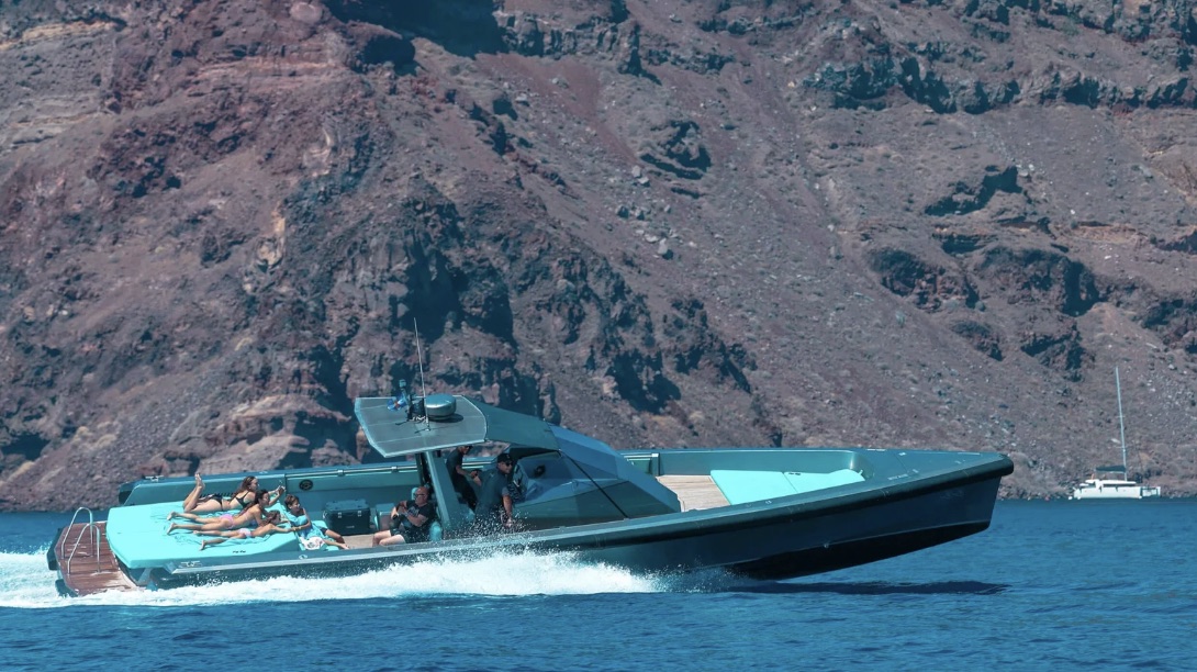 A fast day boat crossing beneath the Santorini caldera cliffs