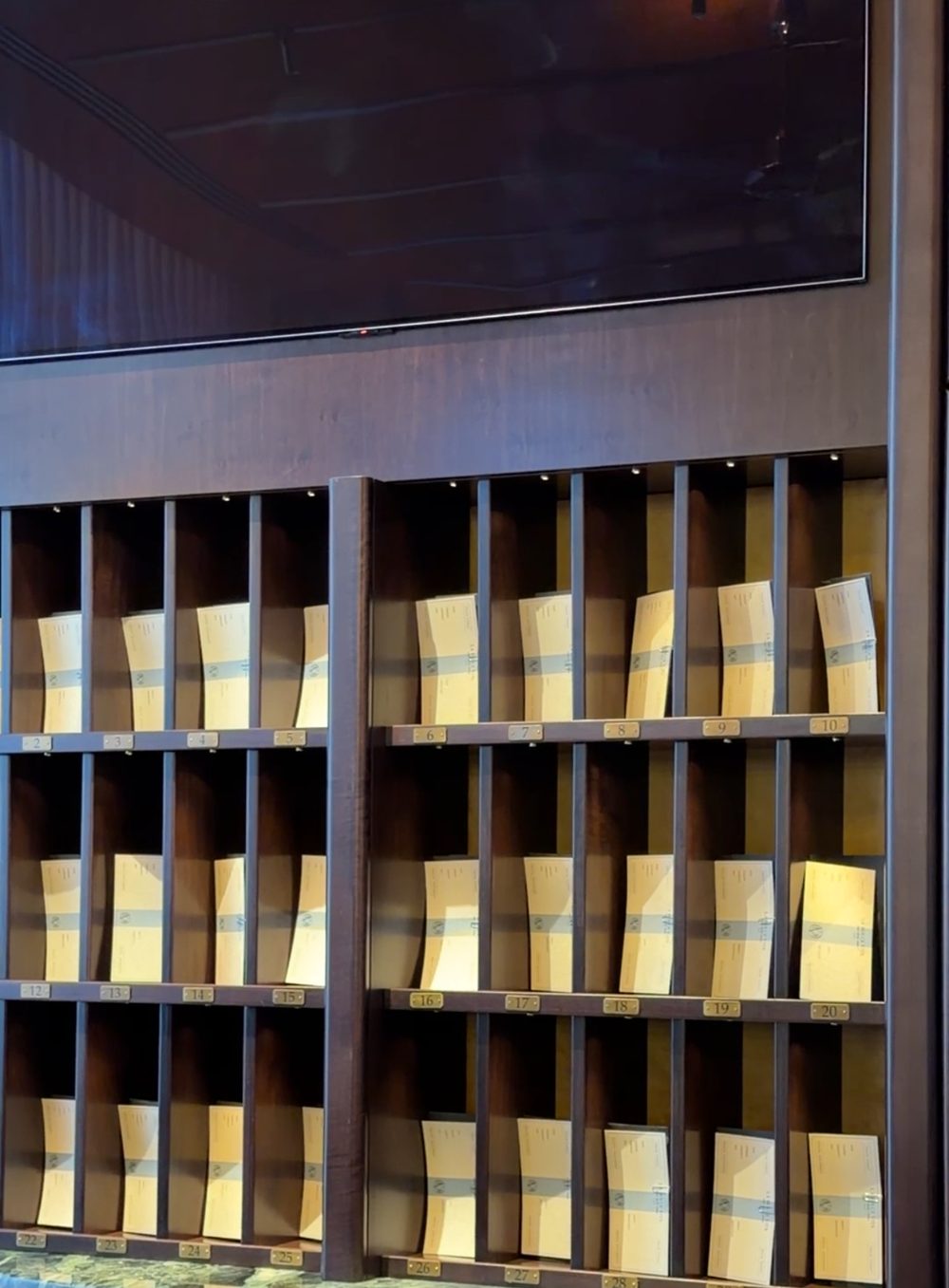 Numbered pigeonholes holding each guest’s boarding documents behind the check-in desk