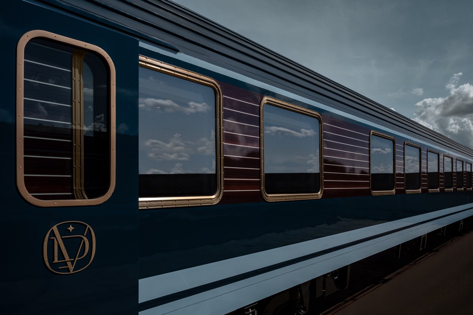 The midnight-blue exterior of La Dolce Vita with brass-framed windows and the gold monogram