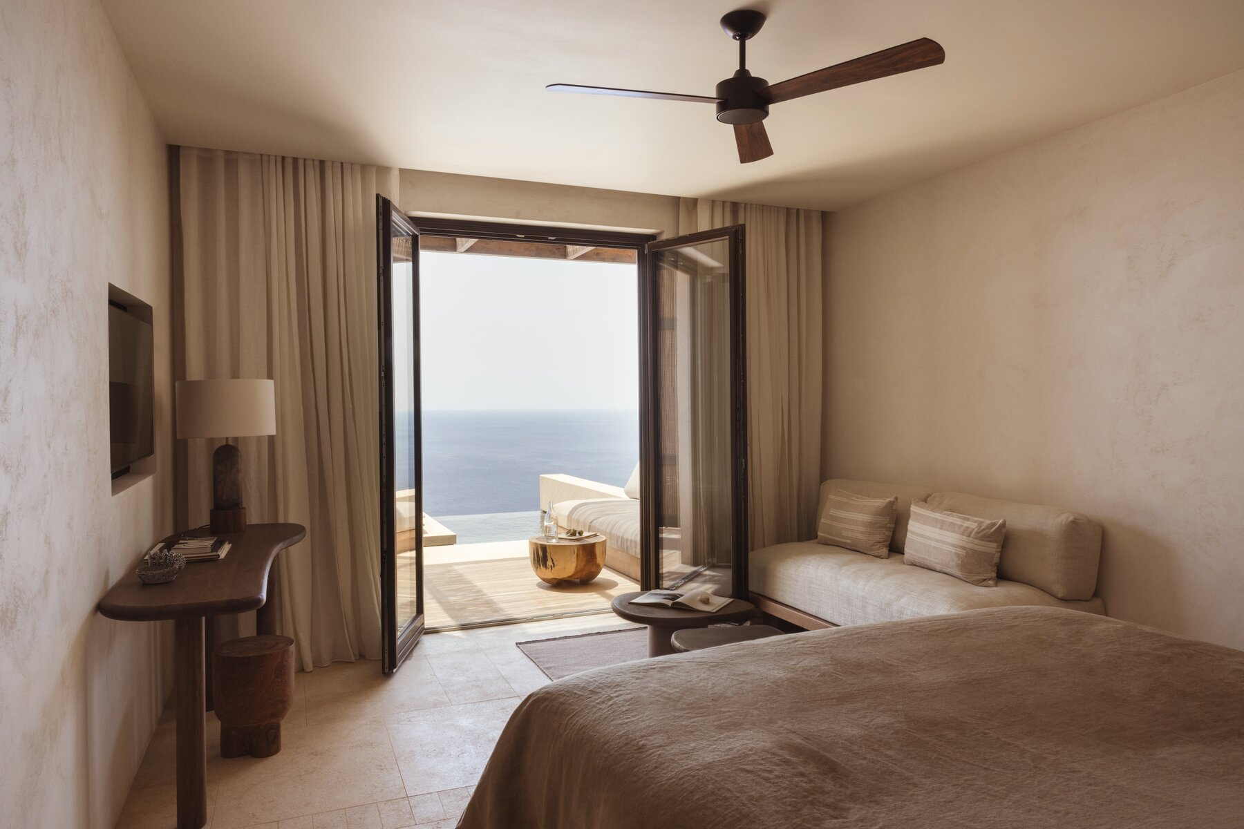 Hotel suite with open doors overlooking the sea