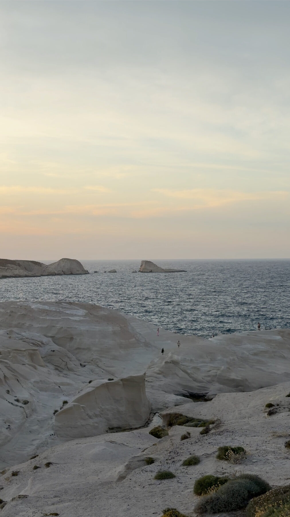 Swimming in clear turquoise water below white rock on Milos