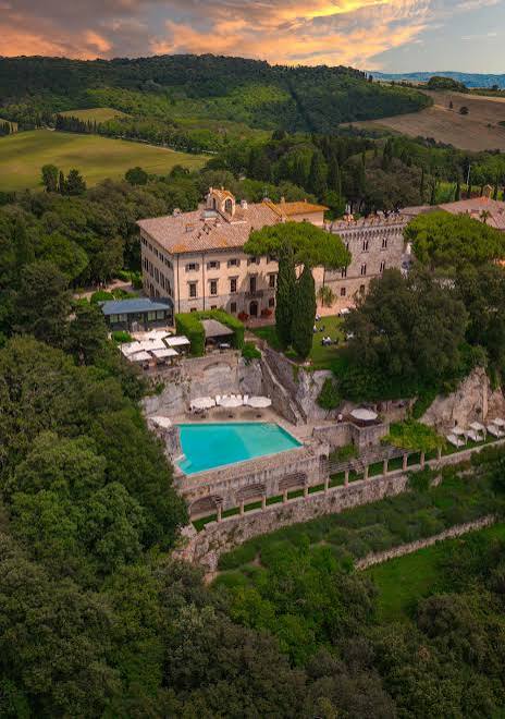 Aerial view of the Borgo Pignano villa, pool and gardens among the Tuscan hills