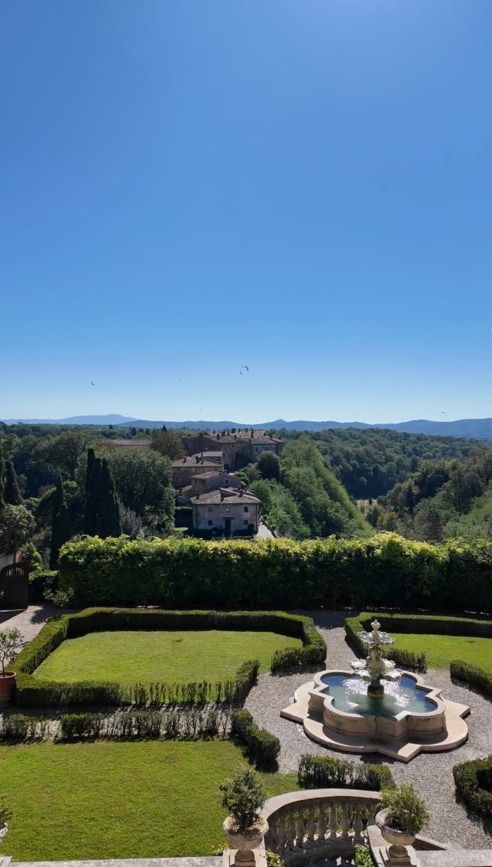 The formal garden and fountain at Il Borro looking out to the medieval borgo and the Valdarno hills