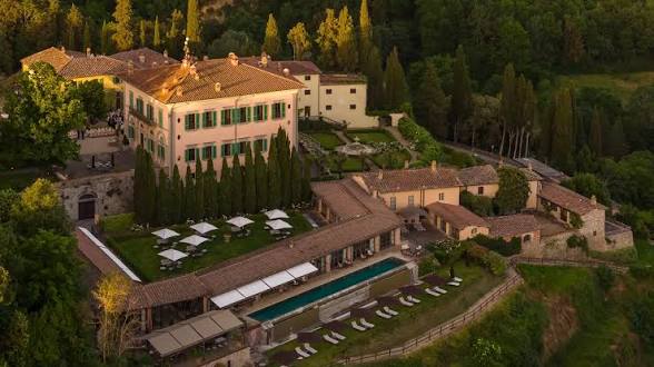 The villa, gardens and long pool at Il Borro at sunset