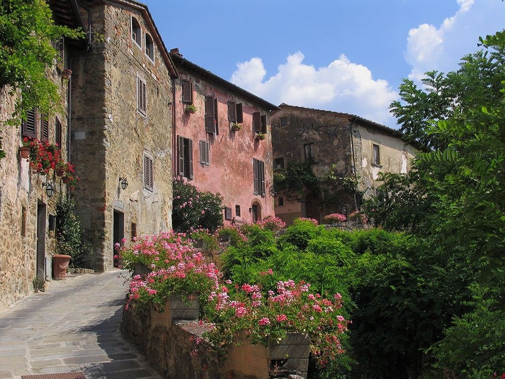 Stone and pink houses with flower boxes along a lane in the Il Borro borgo